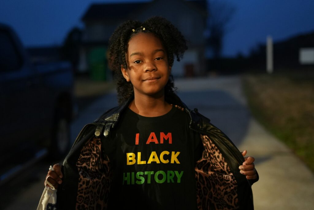 A Black girl with a t-shirt that says I am Black history