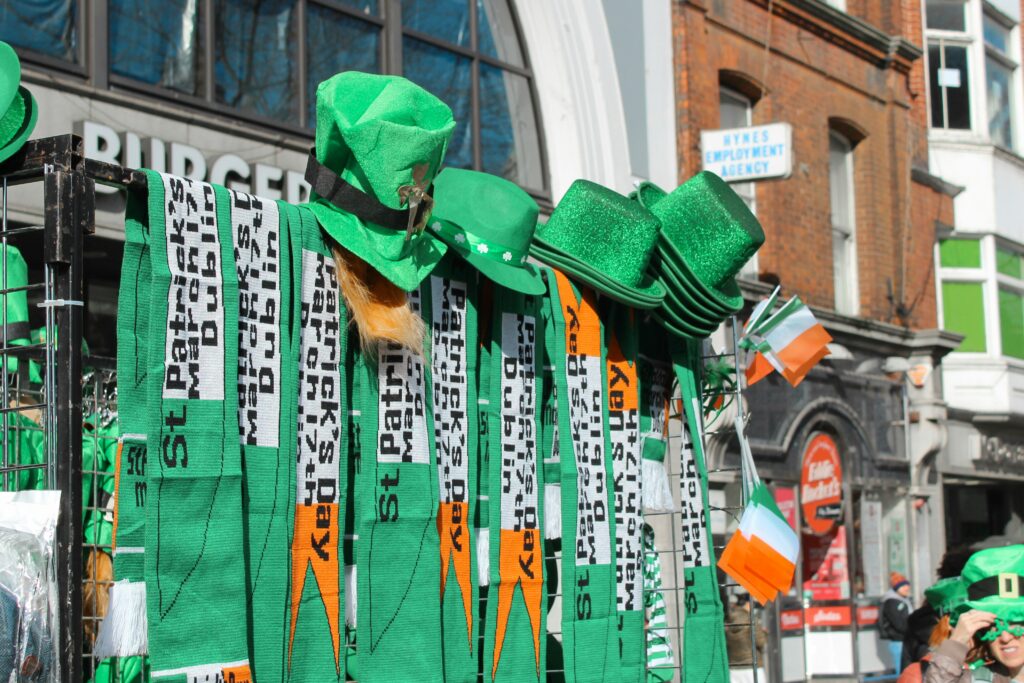 a-group-of-people-walking-down-a-street-next-to-a-tall-building with st patrick's day banners