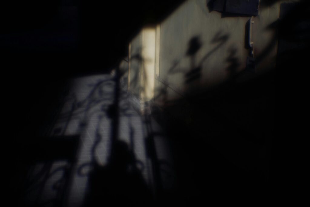 Intriguing play of light and shadows on a wall creating a mysterious atmosphere.