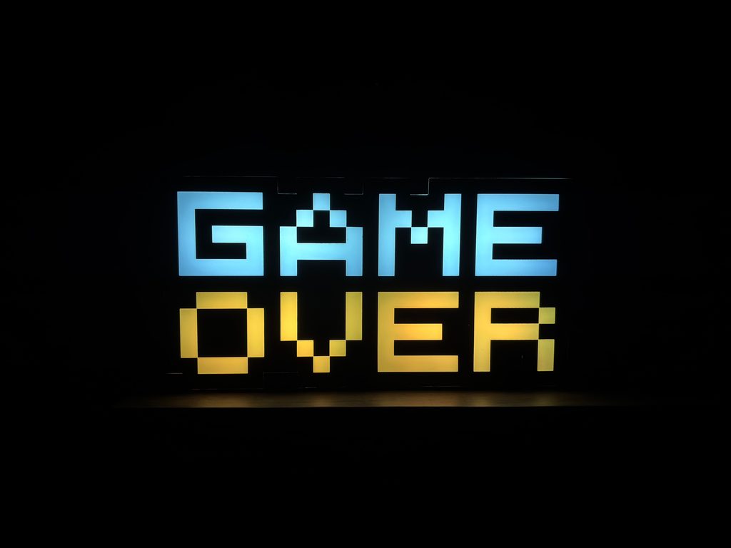 GAME OVER in neon pixel letters on a black background